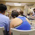 A couple fill out paperwork to receive food from the Bread of Life food pantry run by First United M...