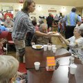  Tom Crosby, volunteer with the Springdale Senior Center, gives a dinner to Jo Ann Heikkila and her ...