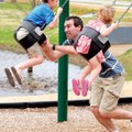 Todd Spindler gives his son Mason Spindler, 7, a big push to get started swinging while Mason’s sist...