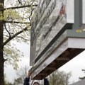  
Lew Indorf (cq) with Ken's Signs, Inc., helps guide an aluminum sign into place Monday outside th...