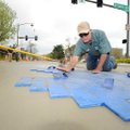 Gene Kelley, crew leader with Fayetteville’s Transportation Division, tamps a concrete stamping mold...