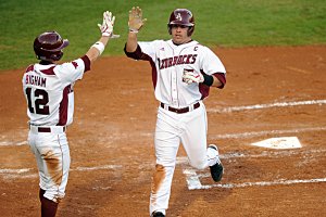 Arkansas' Zack Cox is greeted by Bo Bigham as he scores a run last month in the bottom of the first inning against Saint Louis at Baum Stadium in Fayetteville. The Razorbacks will be facing Tennessee-Martin tonight at 6:30.