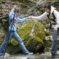 Bailee Wallace, 11, gets help from Field Instructor Naima Montacer crossing a creek while on a hike ...