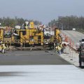 Concrete is laid Friday on the westbound lanes of Wagon Wheel Road east of the intersection with In...