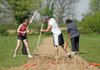 Cobblestone Project volunteers (from right) Raigon Copeland of Rogers, and Josh Mapili and Erica Durr, both of Fayetteville, break up soil Saturday where turnips and beets are to be planted on the farm of David Carter in Benton County.