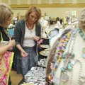  Jill Hall, left, of Rogers, looks at Janet Dills’ booth Saturday during the Rogers Mothers of Presc...