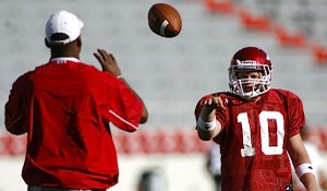 Arkansas quarterback Nick Petrino, right, tosses a ball to quarterbacks coach Garrick McGee before practice Aug. 12, 2009.