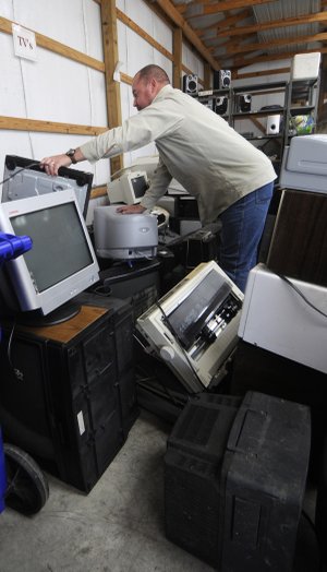 James Mosteller sorts through elecronics Thursday dropped off at the Washington County Environmental Affairs and Recycling in Fayetteville. Electronics can be dropped off for free at Arvest Ballpark on Thursday, Friday and Saturday.