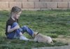 Makayla Ulrich, 6, plays with a puppy March 31 at Bentonville’s Bark Park. The park, opened in May, continues to attract many dog owners and their pets.