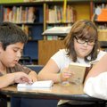 Henry Rodriquez, 11, left, Jasmyn Cordero, 11, and Juan Escobar, 11, read Friday in the school libra...