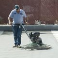 Tim Burton of the Springdale Public Works department floats a newly poured slab of concrete Monday a...