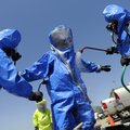 Van Buren firefigher David Moore, center, is washed and scrubbed down inside a decontamination area ...