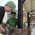  Spencer Erickson, left, and Augusto Garcia work Friday to build a brick pillar around support beams...
