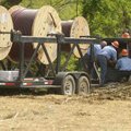 Workers from Ozarks Electric Cooperative work Thursday in a section of the Walnut Crossing Subdivisi...