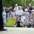 Participants in a Tax Day Tea Party Rally applaud Thursday at the Frisco Stage in downtown Rogers. T...