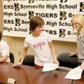  Bentonville High seniors Ethan Sandusky, from left, Elena Sanz and Shannon Sullivan get ready to re...
