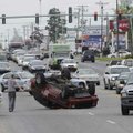  A maroon Jeep Cherokee is overturned Friday in the northbound lane of Thompson Street at the inters...