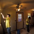 Michael Williams, an eighth-grade science teacher from Bentonville, left, paints the walls of a kitc...