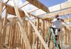 Keith Harviston with ARC Construction measures to install ceiling joists at a home under construction on 37th Street in Rogers. Several homes along the street are in various stages of construction.