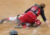 Farmington’s Teighlor Williams slides under Dardanelle catcher Brittany Battenfield to score a run during Saturday’s game in Prairie Grove.