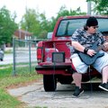 Chris Moore sits on his truck in the driveway of his Springdale home practicing his electric guitar ...