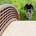 Carlos Barrera crosses Little Sugar Creek on the Lake Bella Vista Trail in Bentonville on Monday. Ba...
