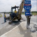 Dan Mowery of the Arkansas Highway and Transportation Department works with a jackhammer attached to...