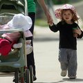 Holland Henry, 2, of Fayetteville holds the hand of her mom, Crystal Henry, as they and Holland's si...