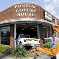 Lee Waltrip with Affordable Towing pulls a white Ford pickup from the window of Pontiac Coffee House...