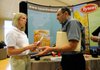 Lowell Jester, right, networks Wednesday with Laura Bennett, corporate recruiter for Tyson Foods, during NorthWest Arkansas Community College’s annual Career Fair in Bentonville. Jester, who has a background in information systems, said he isn’t a student at the school, but attended the fair after learning it was open to the public.