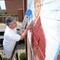 NEW COAT ON KINGFISH - Eric Snodgrass, owner of Snodgrass Signs in Fayetteville, paints a sign Thurs...