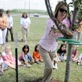 TREE PLANTING - Kimberly Crumby, kindergarten teacher at Harp Elementary School in Springdale, ties ...