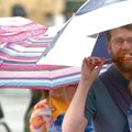 RAIN OR SHINE - Scott Gardner of Fayetteville eats a corn dog Saturday while holding his 1-year-old ...