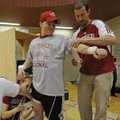 David Keeley, right, secures sensors to Madison Bates’ arm April 16 to analyze his throw as part of ...