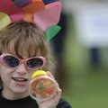 Kirsten Palmer, 7, gets a close-up look at a flower while dressed as a flower Tuesday at the Botanic...
