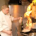 Chef Rob Nelson glazes slices of cantaloupe as he creates a dish at River Grille in Bentonville on A...