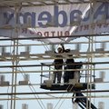  Russ Tucker (left) and Roy Cope, both employees with Best Banner and Sign Company, install the sign...