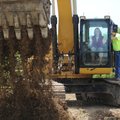 Happy Hollow Elementary School Principal Sharon Pepple turns some earth using a trackhoe with help f...