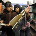 Myra Hernandez, left, and Norma Garcia, both 9, search for books to check out Wednesday at the Roger...