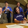 CASEY AT THE SIGNING DESK - Rogers High’s Johanna Casey, center, reacts from the applause of her tea...