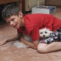 Tayden Larsen, 10, plays with his dog Osito on Friday at the family home in Bentonville.