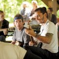 Veteran Jacob George of Fayetteville, center, smiles Saturday while playing the banjo alongside Andr...