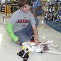 PUPPY LOVE - Zack Yeakley of the Rogers area gives a belly rub to a dog Saturday at the Rogers Petco...