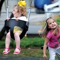 Avery Ainley, 4, right, pushes her sister, Emery Ainley, 18 months, on a swing Sunday at Dave Peel P...