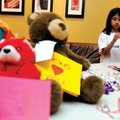 Marisa Fontana, 8, of Rogers makes a ribbon decoration Sunday while collecting teddy bears for Opera...