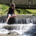 Camden Mask, 5, plays Tuesday in Prairie Creek as it leads into Lake Atalanta in Rogers. Camden was ...
