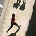 A man runs past Communications Workers of America union members picketing the Windstream Corporation...