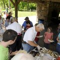 Steve Embrey with the Rogers Noon Kiwanis serves children Wednesday at the Kiwanis’ annual picnic fo...