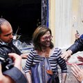A bank employee reacts after being rescued from a fire that broke out when the bank was attacked dur...