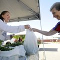 Sara Jones of Sweet “T” Farms hands Norma Stephens her purchase of fresh produce Wednesday at the Ro...
